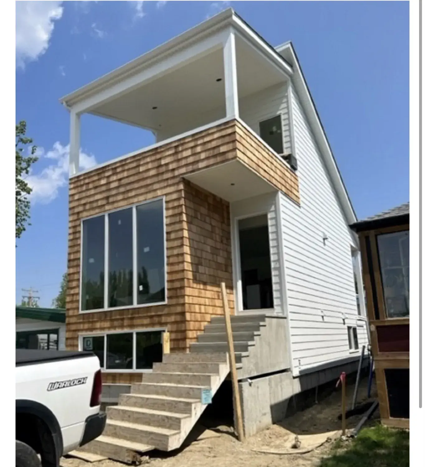 Home with cedar-shake siding and accent trim by PJM Home Advantage