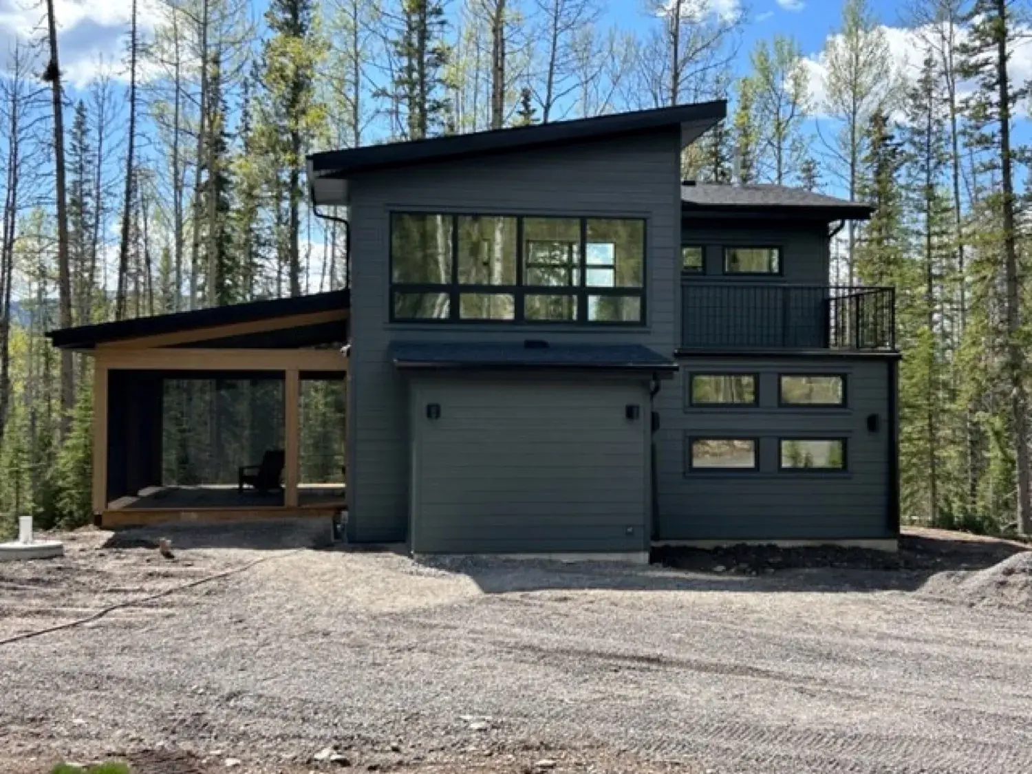 Luxury lakefront home on Sylvan Lake clad in James Hardie HardiePanel vertical siding in a warm grey tone with natural wood soffit accents