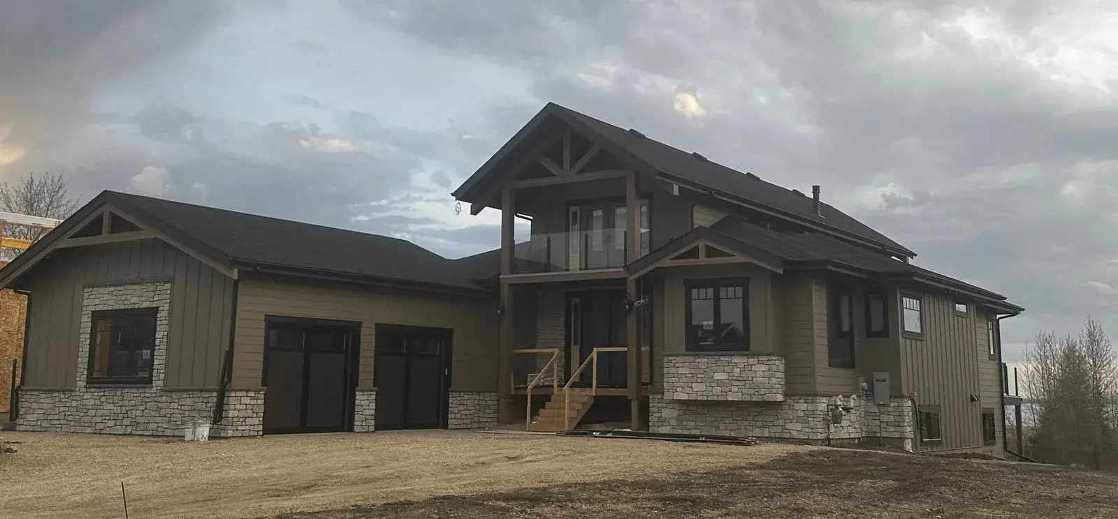 Custom timber-frame acreage home at Gull Lake with board-and-batten and lap siding, stone accents and timber gable brackets, exterior finished by PJM Home Advantage
