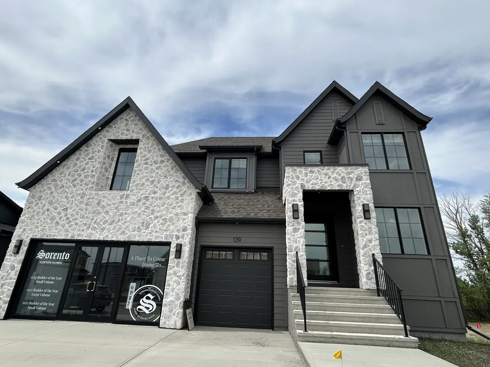 Two-tone stone and dark siding show home in the Red Deer area with full exterior finishing by PJM Home Advantage